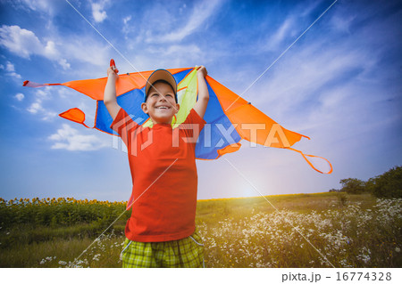 Kid flies a kite into the blue sky 16774328