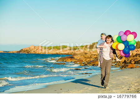 Happy father and son having great time on the beach in sunset light 16779766