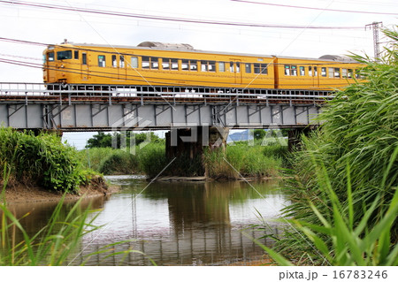 山陽本線の田舎の架橋を走る電車 左端の写真素材