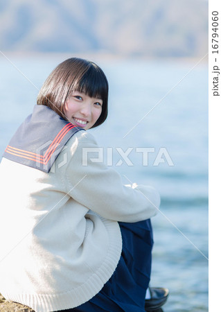 湖とセーラー服を着た女の子の写真素材