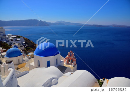 サントリーニ島と青い屋根の教会とエーゲ海の写真素材
