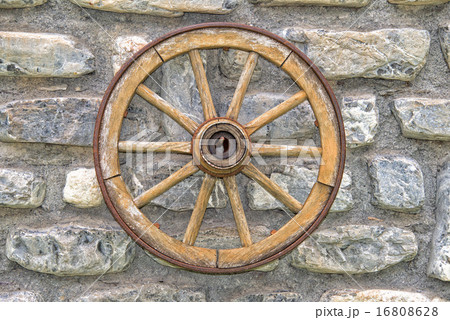 Far west wagon wheel on stone wall 16808628