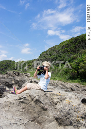 岩場に座り撮影する子供。小さなカメラマン（三浦半島、長浜海岸） 16823936