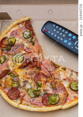pieces pizza in box with tv remote control 16840758