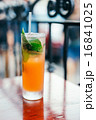Orange cocktail with mint leaves outdoors 16841025