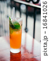 Orange cocktail with mint leaves outdoors 16841026