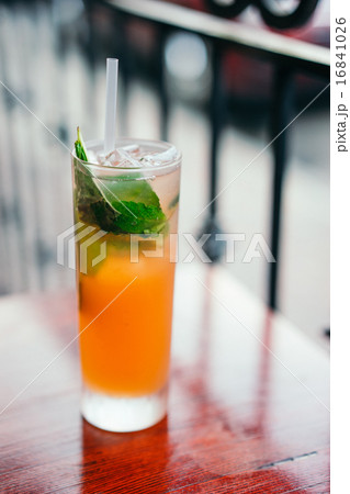 Orange cocktail with mint leaves outdoors 16841026