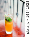 Orange cocktail with mint leaves outdoors 16841028