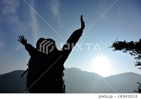 cheering woman hiker open arms at mountain peak 16843018