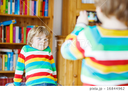 Two little siblings kid boys  making photos with photocamera, in 16844962