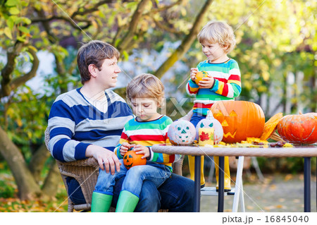 Young dad and two little kids making jack-o-lantern 16845040