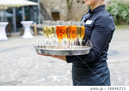 Waitress with dish of champagne and wine glasses 16846253