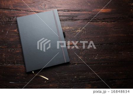 Notepad laying on a old dark wooden table Notepad laying on a old dark wooden table 16848634