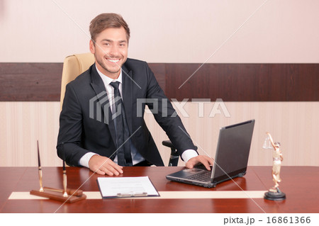 Vivacious lawyer sitting at the table 16861366