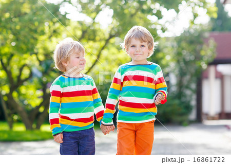Two little brothers children in colorful clothing walking hand i 16861722