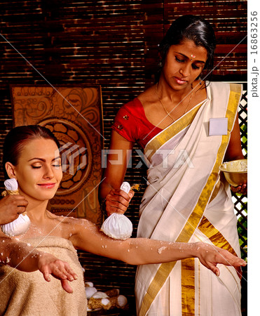 Woman having massage with pouch of rice. 16863256