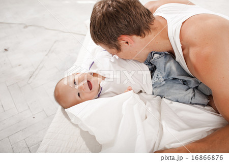 young father with his nine months old son on the bed at home young father with his nine months old son on the bed at home 16866876