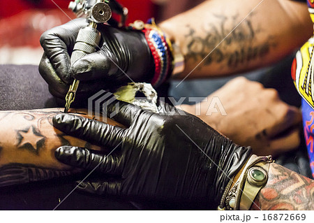 腕にタトゥーを入れる男性の写真素材