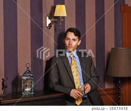 Businessman holding a glass of whiskey. 16873438