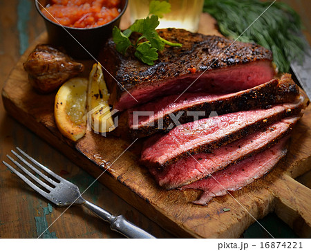Steak with herbs and beer on a wooden background Steak with herbs and beer on a wooden background 16874221