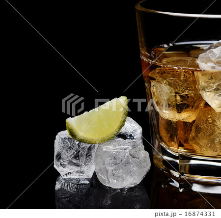 glass of whiskey with ice on a black background 16874331