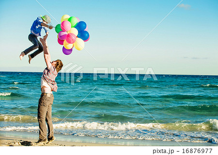 Happy father and son having great time on the beach in sunset light 16876977
