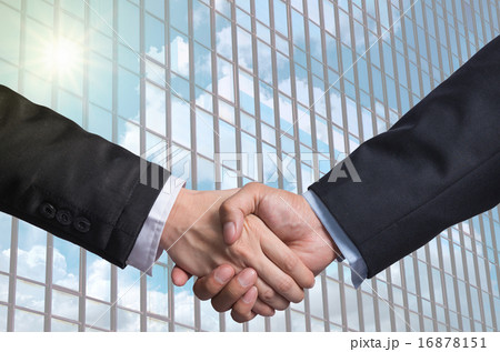 Hand shake between a businessman on Modern glass building backgr 16878151