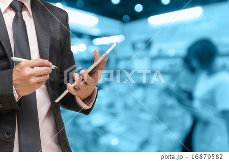 Businessman using the tablet on on Abstract blurred photo of boo 16879582