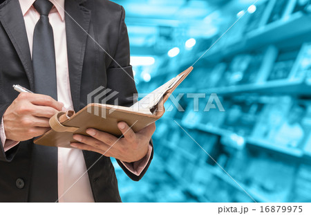 Businessman writing the note book on Abstract blurred photo of b Businessman writing the note book on Abstract blurred photo of b 16879975