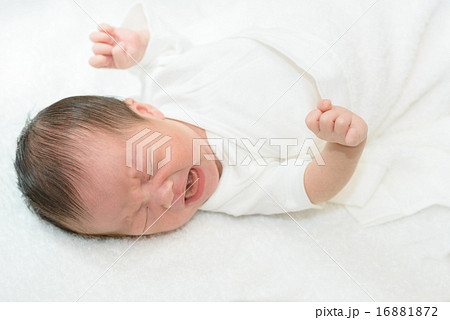 白い産着にくるまれて泣いている新生児 16881872