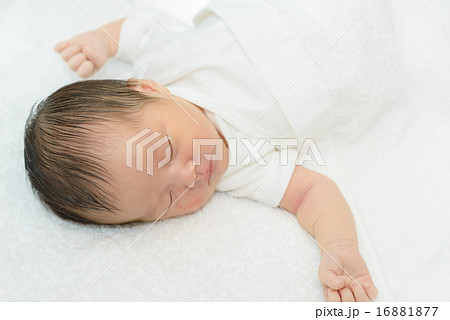 白い産着にくるまれて眠っている新生児 白い産着にくるまれて眠っている新生児 16881877