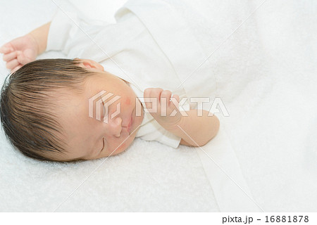 白い産着にくるまれて眠っている新生児 白い産着にくるまれて眠っている新生児 16881878