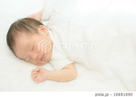 白い産着にくるまれて眠っている新生児 16881890