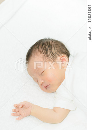 白い産着にくるまれて眠っている新生児 16881893