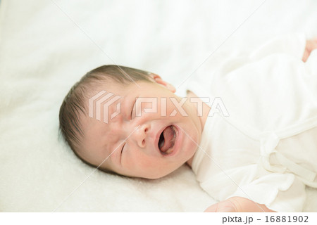 白い産着にくるまれて泣いている新生児 16881902