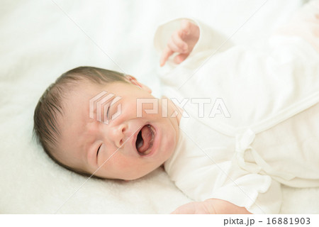 白い産着にくるまれて泣いている新生児 16881903