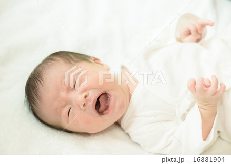 白い産着にくるまれて泣いている新生児 16881904