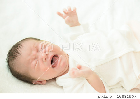 白い産着にくるまれて泣いている新生児 16881907