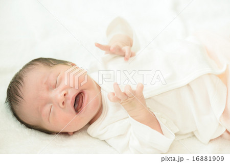 白い産着にくるまれて泣いている新生児 16881909