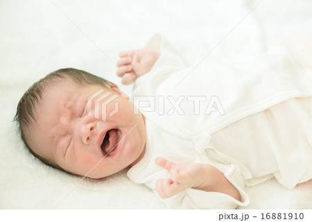 白い産着にくるまれて泣いている新生児 16881910