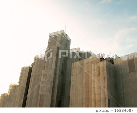 塗装の為に高層マンション全体をメッシュシートで覆われる 16884087