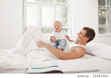 young father with his nine months old son on the bed at home young father with his nine months old son on the bed at home 16887962
