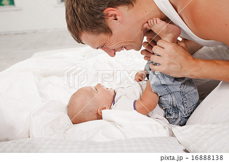 young father with his nine months old son on the bed at home 16888138
