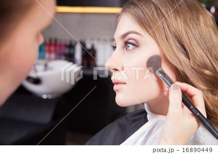 Stylist doing professional make up of young woman Stylist doing professional make up of young woman 16890449
