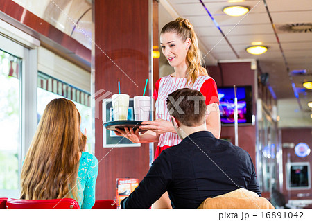 People in American diner or restaurant eating fast food 16891042