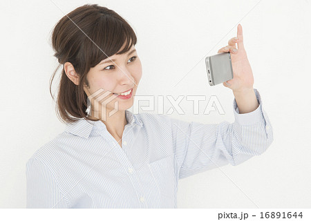 携帯電話で撮影をする女性 携帯電話で撮影をする女性 16891644