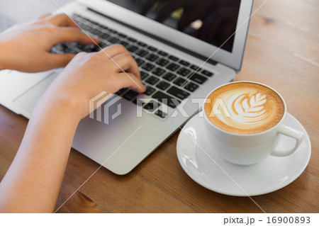 Closeup of business woman hand typing on laptop keyboard and cof 16900893