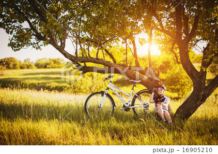 cute sportswoman Cyclist resting under a tree cute sportswoman Cyclist resting under a tree 16905210