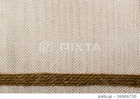 Jute ribbon on sack cloth background Jute ribbon on sack cloth background 16906730