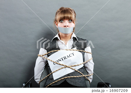 Businesswoman bound by contract with taped mouth. 16907209
